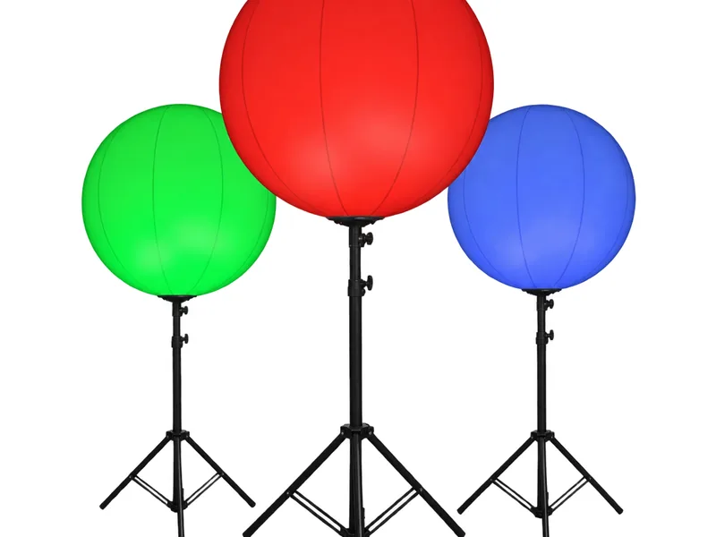 Three round RGBW balloon lights glowing red, green and blue on tripods, white background